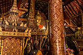 Wat Xieng Thong temple in Luang Prabang, Laos. The sim s interior is extensively decorated with intricate gold stencilling on black lacquer. Large stencilled teak wood pillars support the roof.  